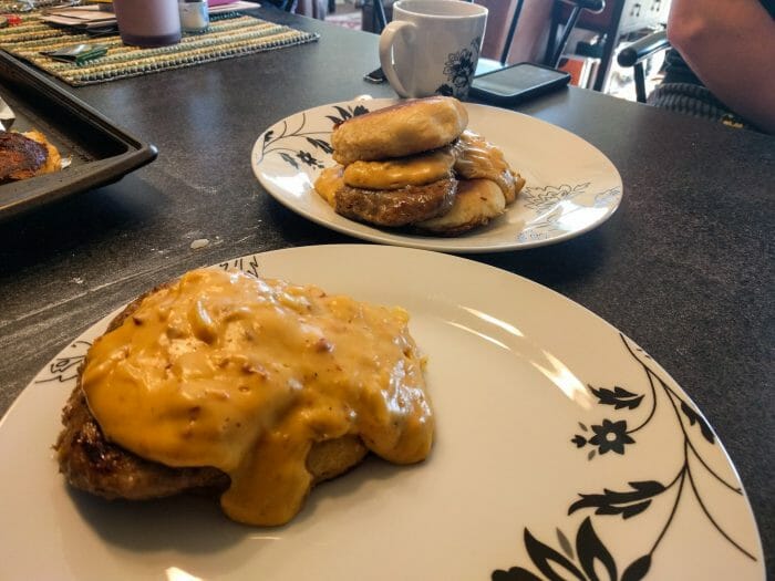 Two plates of biscuits and gravy with beer cheese sauce. 