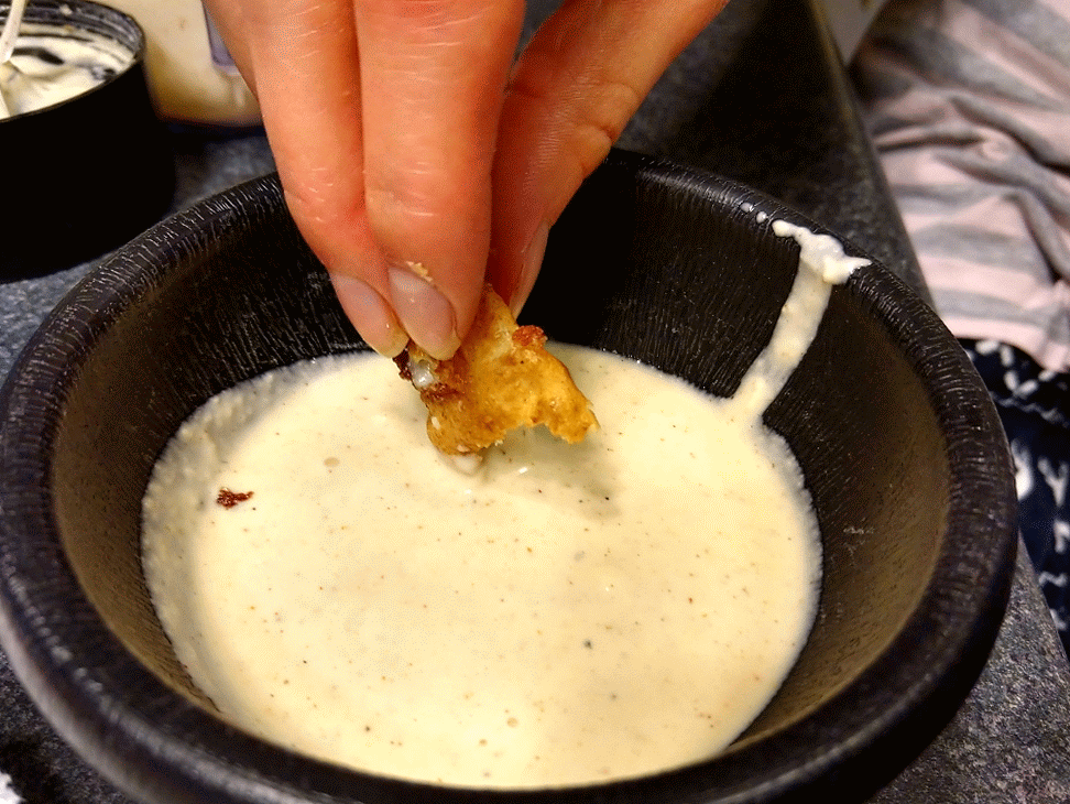Dipping cheese curds in a garlic aioli